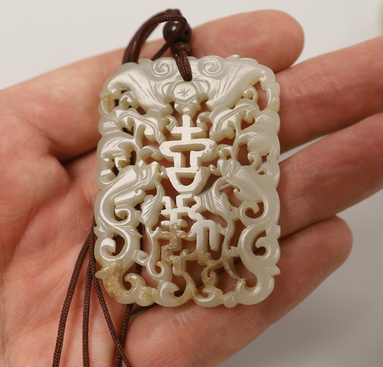 A Chinese pale celadon jade belt hook, 18th / 19th century and a similar 19th century pendant, pendant 5.5 cm long